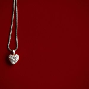 luxury heart necklace with stylish diamonds on red background with space for text, present and love concept, valentine's day , wedding gift, birthday. isolated